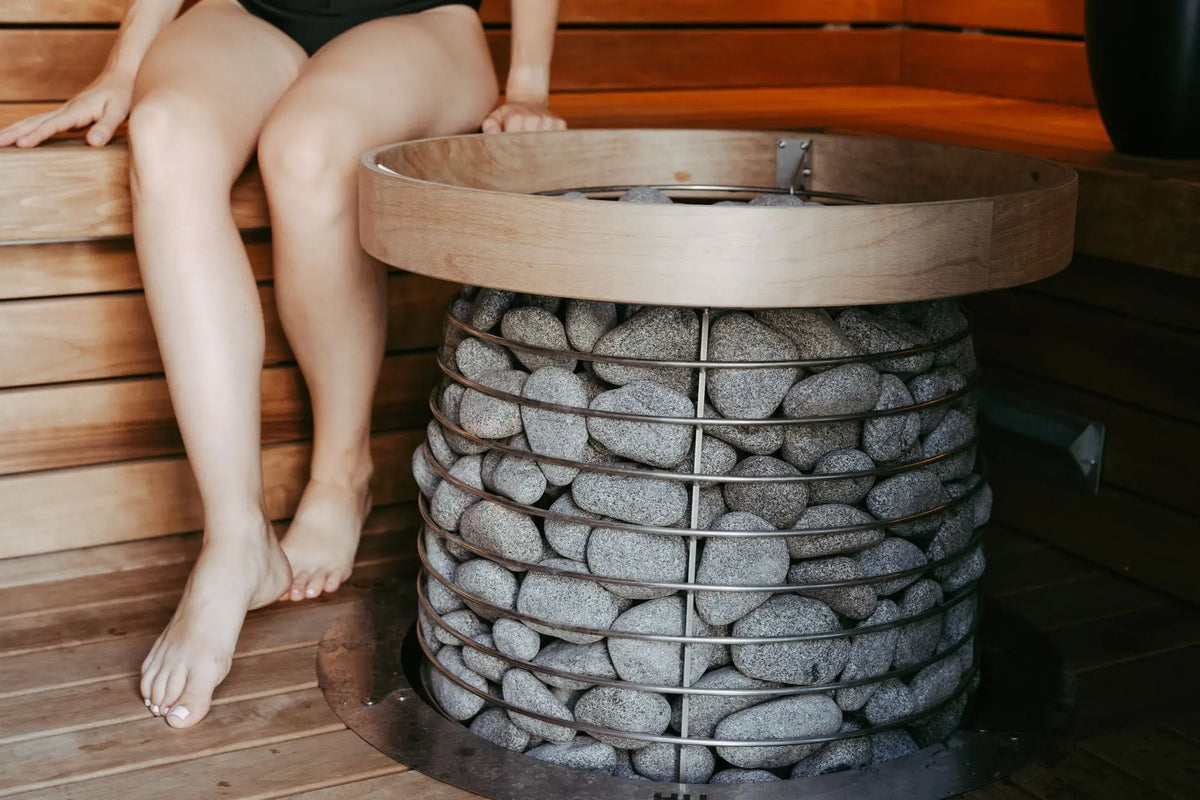 Minimalist sauna featuring a stylish stone heater and nordic design elements.