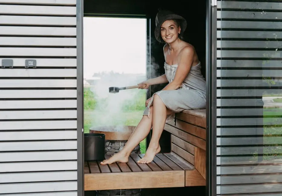 A woman happily relaxes in a stylish sauna, emphasizing comfort and modern design.