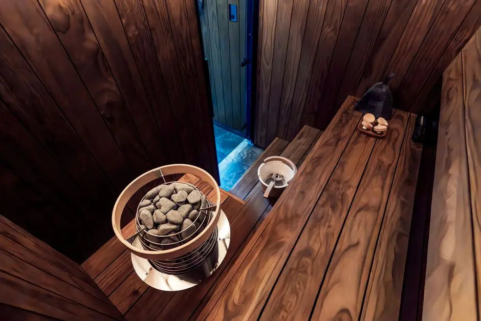 A contemporary indoor sauna with wooden benches and an electric heater, showcasing Nordic design elements.