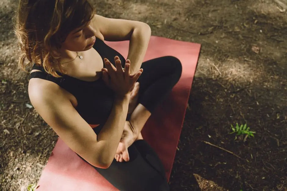 A woman doing yoga outdoors on a mat, embodying tranquility and focus.