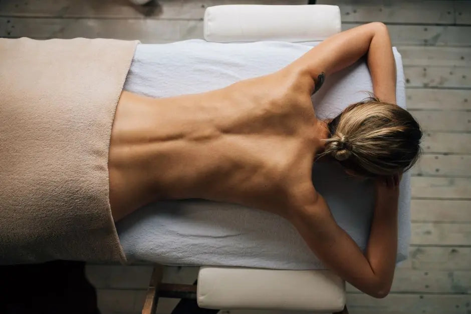 Top view of a person enjoying relaxation and self-care in a serene massage therapy setting.