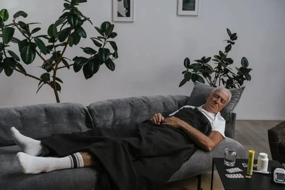 Elderly man resting on sofa with medical supplies nearby, surrounded by houseplants.